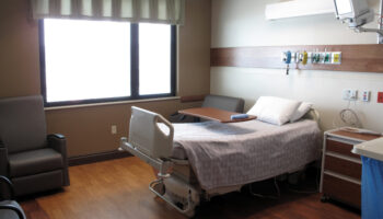 Inside of a hospital room with a bed, where someone might undergo medical detox
