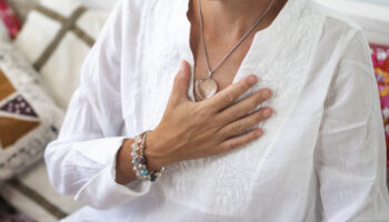 A woman lies a hand on her chest, feeling grateful