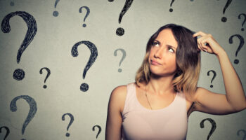 A woman surrounded by question marks, suggesting confusion or amnesia