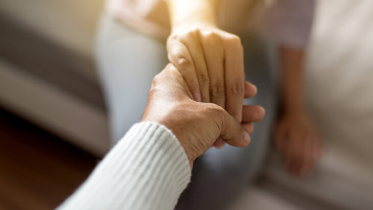 two people holding hands in a supportive fashion