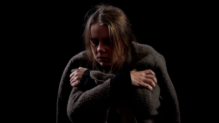 A destitute-looking woman suffering from opioid withdrawal symptoms