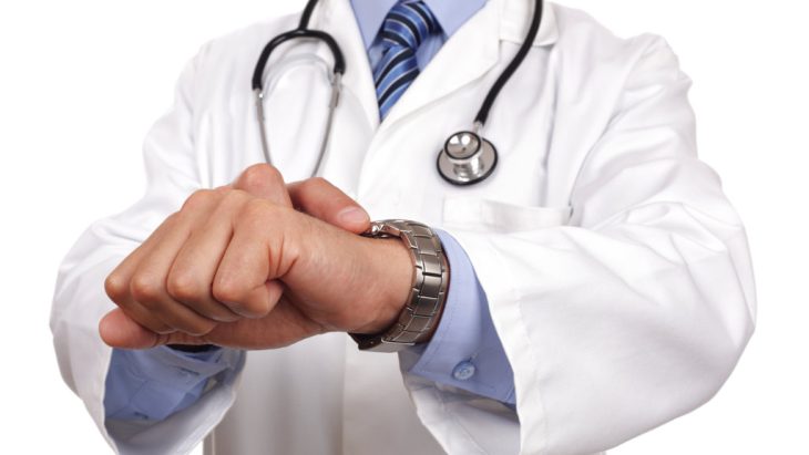A doctor checks their watch