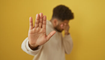 A man holds up his hand in a 'stop' motion