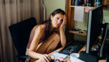 A remote worker clutches their head, coping with anxiety and xanax withdrawal
