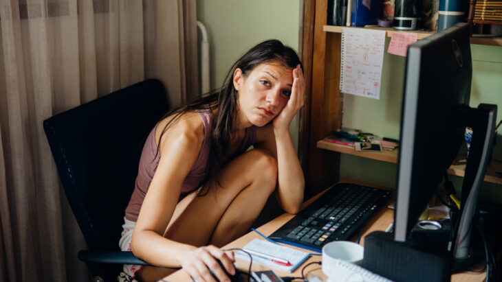 A remote worker clutches their head, coping with anxiety and xanax withdrawal