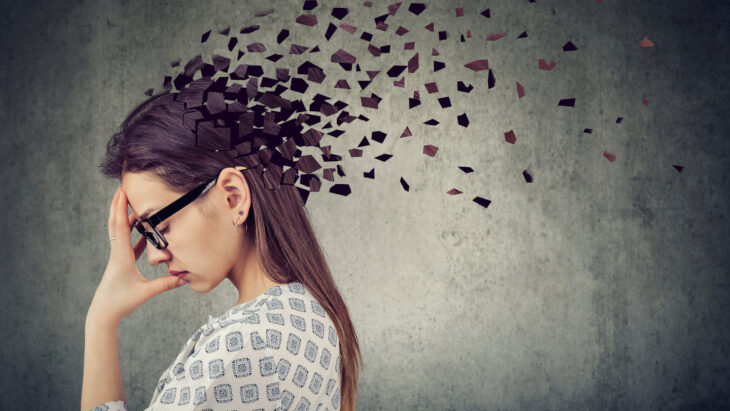A woman clutches her head in an artistic representation of memory loss
