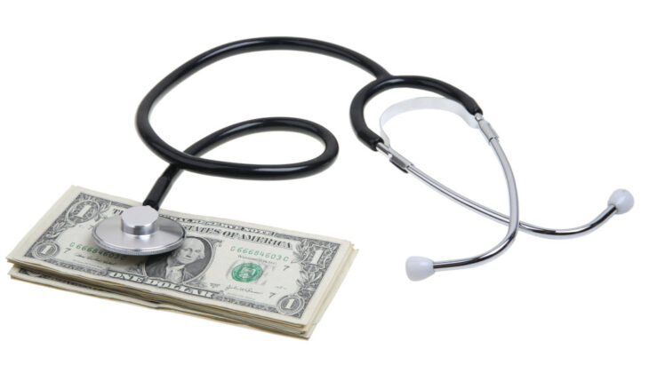 a stethoscope with a stack of dollars