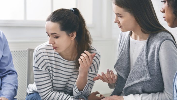 Two people speaking with each other in a support group setting