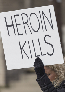 mom holding heroin kills sign