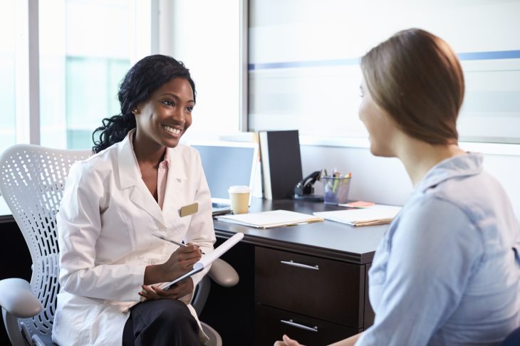 A doctor speaks with a patient during an appointment