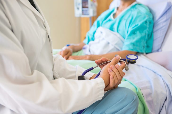 A doctor speaks with a patient who is attending inpatient care