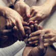 People hold hands over bibles at a Christian detox center