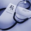 an Rx prescription sheet with a stethoscope sitting on top of it
