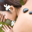 A woman undergoing hot stone therapy, a common feature at luxury and holistic rehab centers