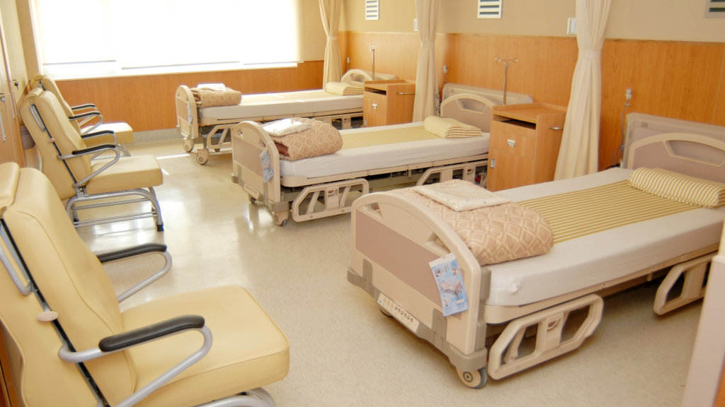 A view inside a residential rehab center, with hospital beds lined up in a row.