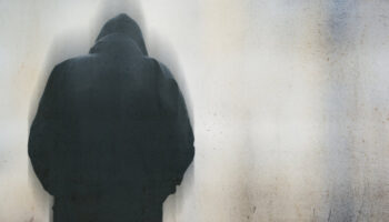 A view from behind of a depressed person wearing a dark hoodie. Learn more about detox and treatment for crack addiction here.
