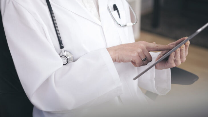 A doctor points at a tablet. Learn more about the difference of rapid detox vs conventional detox, here.