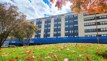 Exterior view of Bergen New Bridge Medical Center building with manicured grounds and autumn foliage