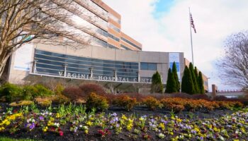 Exterior front entrance of Virginia Hospital Center showing landscaped flower beds, signage, and facility facade