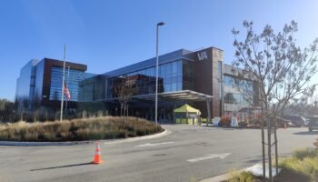 Exterior view of treatment facility showing modern architecture with landscaped courtyard area and patient parking lot