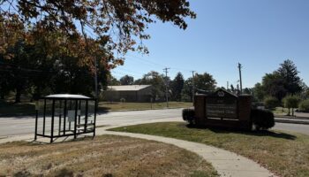 Exterior view of facility with VA Department of Veterans Affairs Outpatient Clinic signage, parking area, bus shelter, and grounds