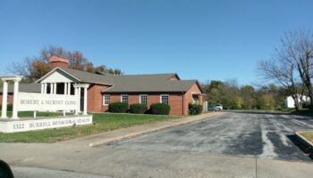 Exterior view of Robert J. Murney Clinic brick building with signage, driveway, and landscaping