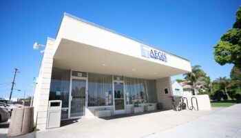 Exterior view of Aegis Treatment Centers Santa Maria showing white building facade, main entrance with glass doors, signage, and parking area