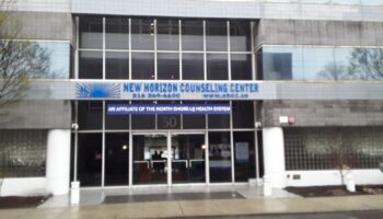 Exterior front entrance of New Horizon Counseling Center showing glass doors, signage, and modern building facade with landscaping