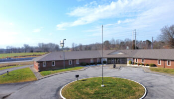 Exterior front view of brick treatment facility with parking area, landscaping, and building entrance