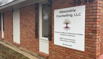 Exterior view of brick building with Alexandria Counseling LLC and Palmetto Addiction Recovery Center signage displayed on facade