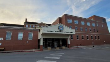Exterior view of Des Moines VA Medical Center brick building with main entrance portico displaying VA seal and institutional signage