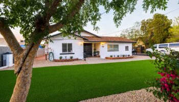 Exterior front of treatment facility showing main entrance, landscaped lawn, desert vegetation, and parking area