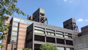 Exterior view of modern medical facility with brick facade, steel framework, and large windows on multi-story building