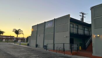 Exterior view of Aegis Treatment Centers facility at dusk with illuminated signage and parking area visible