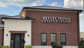 Exterior front facade of Reflections Lifestyle Center showing brick and stone construction with main entrance signage