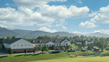 Exterior view of Cumberland Heights treatment facility showing main buildings, manicured grounds, and mountain backdrop