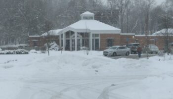 Exterior view of treatment facility main entrance with brick building, white columned entry, and parking area during winter conditions