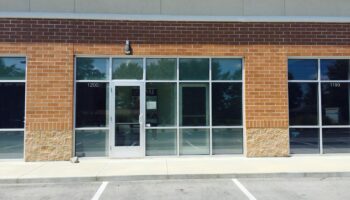 Exterior showing brick and stone commercial building facade with glass entry doors and windows