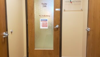 Interior hallway showing tile flooring, wooden doors, and Hope Network Center for Recovery facility signage on wall