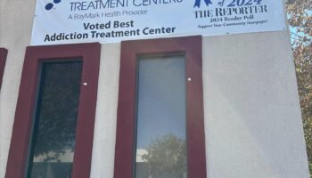 Exterior front facade showing MedMark Treatment Centers address 1143 with Best Addiction Treatment Center award banner and red-framed entrance.