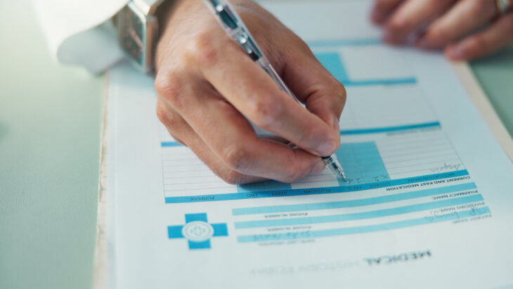 A doctor signing forms for medical insurance. Does Cigna offer detox or rehab coverage? Learn more here.
